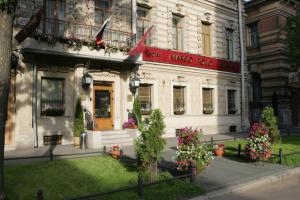 een wit gebouw met bloemen ervoor bij Marco Polo St Petersburg Boutique Hotel in Sint-Petersburg
