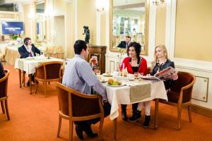 grupa ludzi siedzących przy stole w restauracji w obiekcie Spa Hotel Gloria w mieście Przemyśl