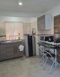 a kitchen with a sink and a refrigerator and a table at Villa Layla Santa Marta in Santa Marta