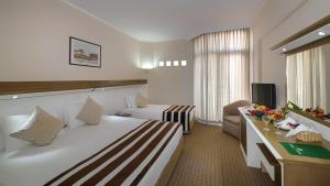 a hotel room with a large bed and a couch at Green Max Hotel in Belek
