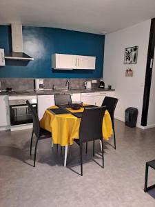 uma sala de jantar com uma mesa amarela e cadeiras em Logement idéal curistes em Rochefort