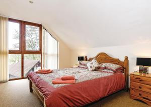 a bedroom with a large bed and a window at Exmoor Gate Lodges in Chipstable