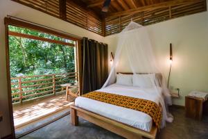 a bedroom with a bed and a large window at Satta Lodge in Puerto Viejo