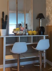 a counter with two white stools in a kitchen at Chez Margarett in Royan