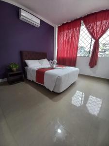 - une chambre avec un grand lit et des rideaux rouges dans l'établissement HOTEL DIAMANTE, à Santo Domingo de los Colorados