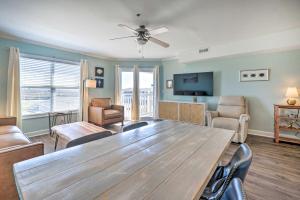 a living room with a large wooden table and chairs at Oak Island Condo - Walk to the Beach! in Oak Island