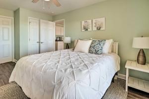 a bedroom with a white bed and a ceiling fan at Oak Island Condo - Walk to the Beach! in Oak Island