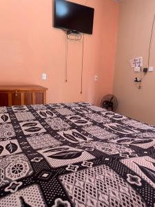 una camera da letto con una trapunta bianca e nera su un letto di casa rural Bon Tempo a Pirenópolis