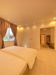 a bedroom with a large bed and a window at فيلا آفيري Aviary villa in Al-ʿUla