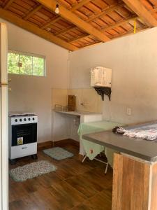 een keuken met een fornuis en een tafel in een kamer bij casa rural Bon Tempo in Pirenópolis