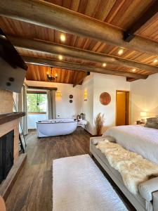 een slaapkamer met een bed en een bad bij Flor de Minas in Monte Verde