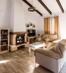 sala de estar con sofá y chimenea en CASA RURAL LOS ALTOS, en Ojuelos Altos