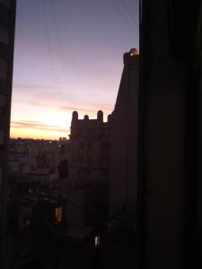 una puesta de sol vista desde la ventana de un edificio en Hermoso Apartamento en el centro de Buenos Aires. en Buenos Aires
