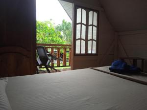 um quarto com uma cama e um alpendre com uma janela em Hotel Karupa Amazonas em Letícia