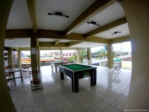 a room with a pool table and some tables at Hotel Sirena in Praia Grande