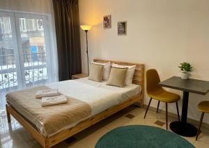 a bedroom with a bed and a table and a window at Bubble Hostel in Kraków