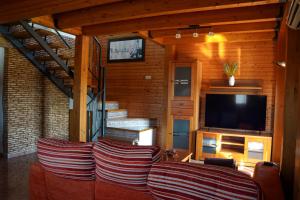 Casa la Pau في ديلتيبري: غرفة معيشة مع أريكة وتلفزيون بشاشة مسطحة