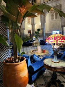 a living room with a blue couch and a plant at Le Riad Palais d'hotes Suites & Spa Fes in Fez