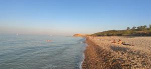 a group of people sitting on a beach next to the water at Villa Marianna in Vasto