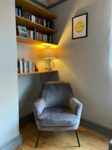 une chaise dans une chambre avec une étagère dans l'établissement Grove House - 4 Bedroom sleeps 8 only 1 mile from centre, à Farnley
