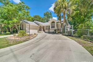 a house with palm trees in the driveway at Crystal River Vacation Rental on Canal! in Crystal River