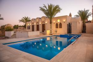 a villa with a swimming pool in front of a house at Sun house in Tunis