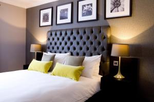 a bedroom with a large white bed with yellow pillows at The Bulls Head Hotel in Hale