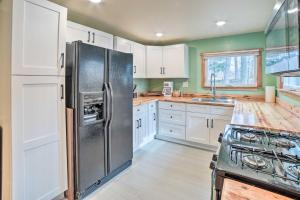 a kitchen with white cabinets and a stainless steel refrigerator at Indiana Vacation Rental Near Lake Michigan in Valparaiso +18 photos