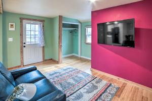 a living room with a couch and a tv on a wall at Indiana Vacation Rental Near Lake Michigan in Valparaiso