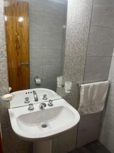 bagno con lavandino bianco e specchio di Departamento Ciudad de Tupungato a Tupungato