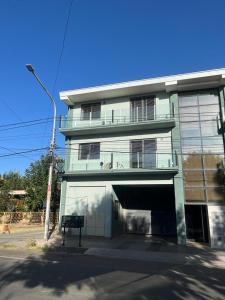 Un grand bâtiment avec un garage se trouve en face de l'établissement. dans l'établissement Departamento Ciudad de Tupungato, à Tupungato