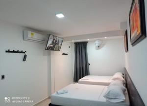 a room with two beds and a window at HOTEL DIAMOND BGA in Bucaramanga