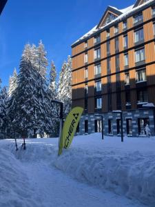 a sign in the snow in front of a building at Woodside Kopaonik & SPA by Slopeview in Kopaonik +66 photos