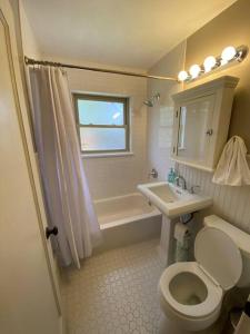 a white bathroom with a toilet and a sink at The House You Want - Perfect location & No Chores! in Denver