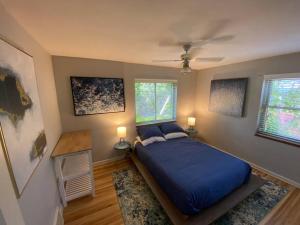 a bedroom with a blue bed and two windows at The House You Want - Perfect location & No Chores! in Denver