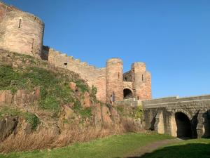a castle on top of a hill with a bridge at Brada View Bamburgh in Bamburgh