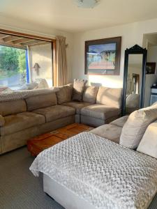 a living room with a couch and a table at Otago Peninsula Paradise in Dunedin