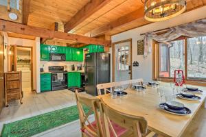 a kitchen with a wooden table and green cabinets at 4 Mi to Tubing Cozy Bushkill Cabin with Deck! in Bushkill