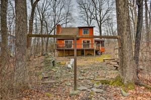 une maison orange au milieu des bois dans l'établissement Cozy Bushkill Cabin with Deck Near Shawnee Mountain!, à Bushkill