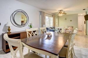 uma sala de jantar com uma mesa, cadeiras e um espelho em Bradenton Cottage with Pool, 12 Mi to Beaches! em Bradenton