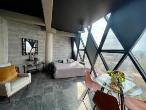a bedroom with a bed and a glass table at Loft industrial vista a los volcanes in Cholula