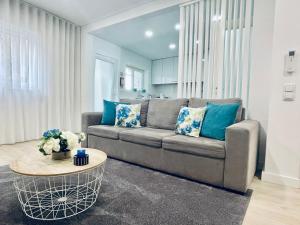uma sala de estar com um sofá e uma mesa em Central Tiled Apartment em Aveiro