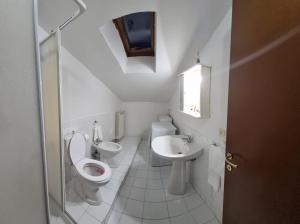 a white bathroom with a toilet and a sink at Residenza Infante in Avezzano
