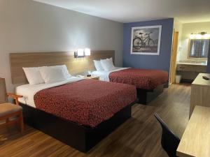 una camera d'albergo con due letti e un tavolo di Days Inn by Wyndham Portland/Corpus Christi a Portland