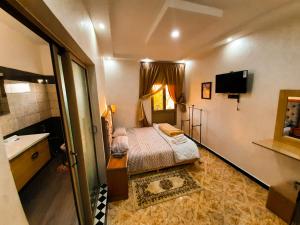 a small bedroom with a bed and a sink at DARKOM in Dakhla