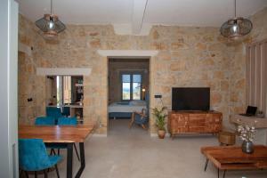 a living room with a stone wall at Cavos Luxury Apartments in Kissamos