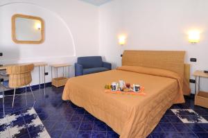 a hotel room with a bed with a tray of food on it at Hotel Aura in Vulcano +16 photos