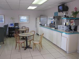 a restaurant with a table and chairs and a kitchen at Westmont Inn - Lakeland in Lakeland