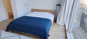 uma cama num quarto ao lado de uma janela em Traditional chic, High Ceilings' apt Aircos and Garage em Antuérpia