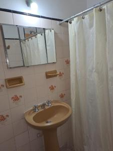 baño con lavabo y cortina de ducha en La Toscana en Salta
